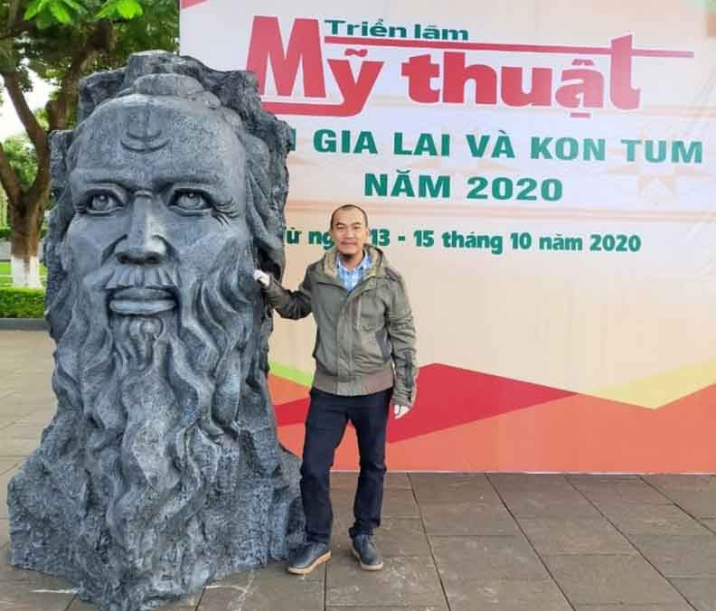 Nhà điêu khắc Nguyễn Vinh bên tác phẩm “Anh hùng Núp”. Ảnh: T.L