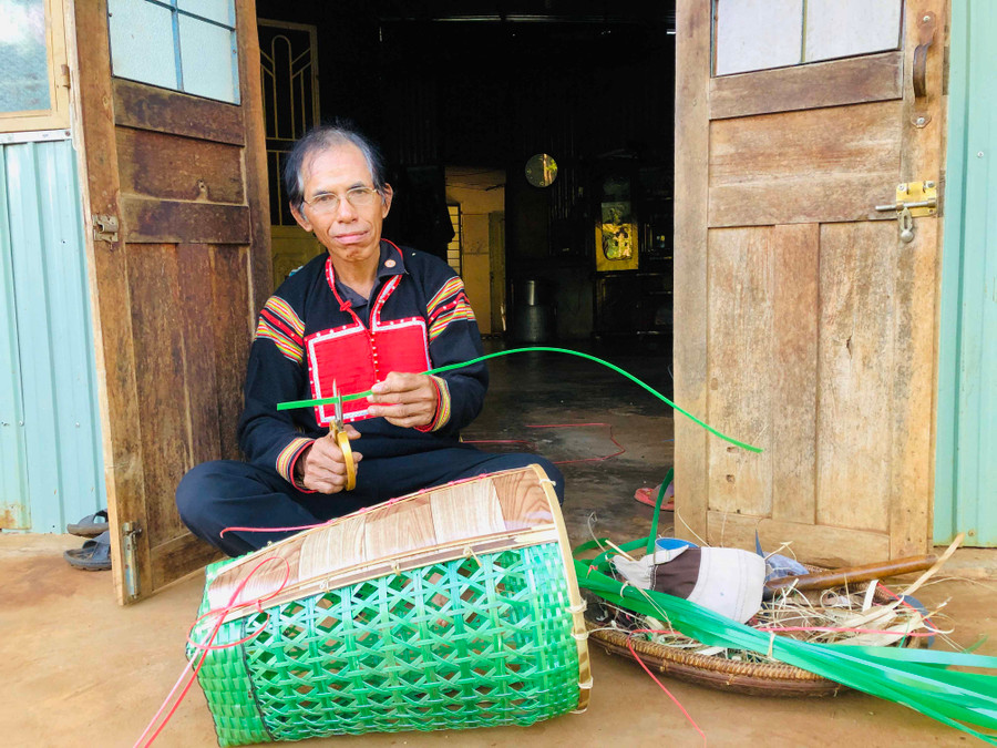Ông Rơ Châm Nguich đan gùi bằng các sợi dây nhựa. Ảnh: Phan Lài