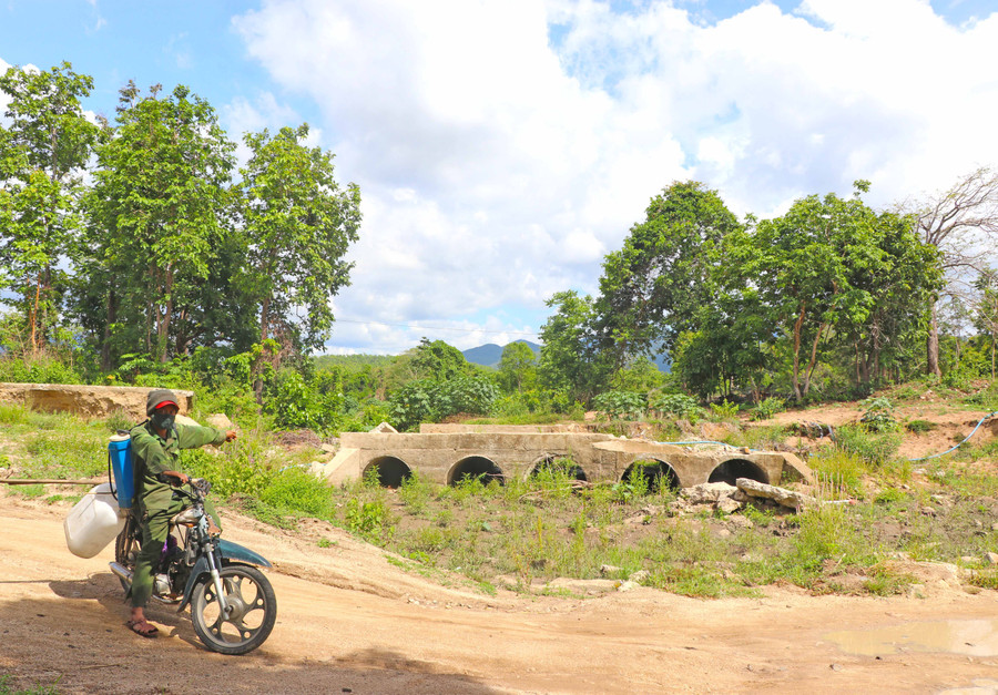 Hàng ngày, anh Đinh Grơnh (làng Hrách, xã Đak Kơ Ning, huyện Kông Chro) phải đi qua đường tạm ở lòng suối Tkắt để đến khu sản xuất. Ảnh: Ngọc Minh