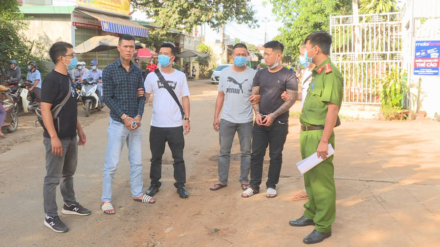 Đạt và Nghĩa (không đeo khẩu trang) bị công an bắt giữ.