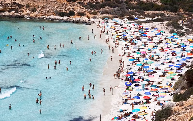 Du khách trên bãi biển trên đảo Lampedusa của Sicilia ngày 22/6/2021 (Ảnh: REUTERS)