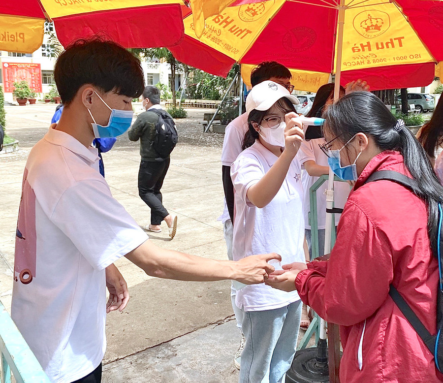 Tất cả thí sinh được kiểm tra thân nhiệt, rửa tay sát khuẩn và bắt buộc đeo khẩu trang trước khi bước vào khu vực thi. Ảnh: Mộc Trà Tất cả thí sinh được kiểm tra thân nhiệt, rửa tay sát khuẩn và bắt buộc đeo khẩu trang trước khi bước vào khu vực thi. Ảnh: Mộc Trà