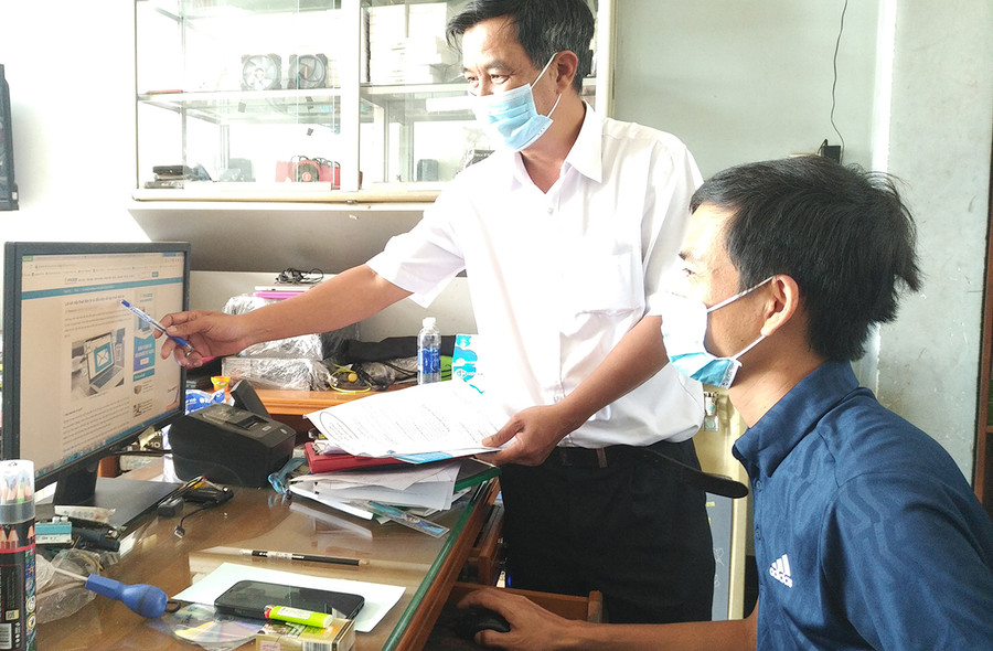  Cán bộ Chi cục Thuế TP. Pleiku hướng dẫn hộ cá nhân kinh doanh nộp thuế điện tử. Ảnh: Sơn Ca