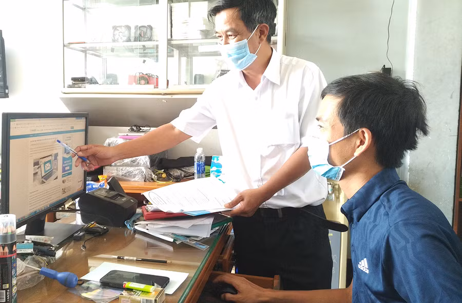  Cán bộ Chi cục Thuế TP. Pleiku hướng dẫn hộ cá nhân kinh doanh nộp thuế điện tử. Ảnh: Sơn Ca