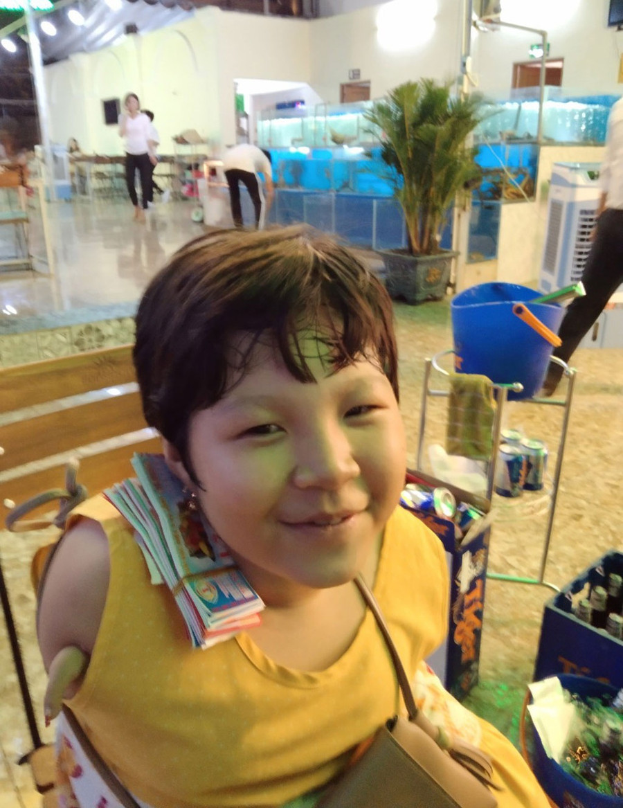 Bé Nhí không có tay đi bán vé số. ẢNH: QUANG VIÊN