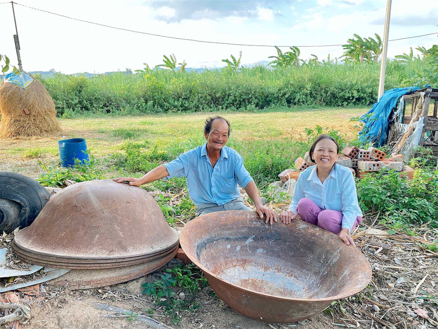 Vợ chồng ông Nguyễn Thới (thôn 5, xã Thành An, thị xã An Khê) bên những chiếc chảo gang từng theo mình làm che mía nấu đường một thời. Ảnh: Hồng Thi