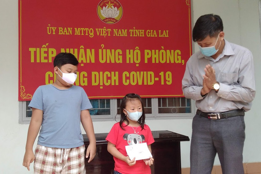  Em Nguyên Thảo (áo đỏ) đã dành số tiền tiết kiệm heo đất để ủng hộ công tác phòng-chống Covid-19. Ảnh: Lê Đại