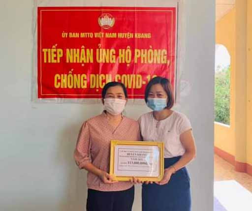Chủ tịch Ủy ban MTTQ Việt Nam thị trấn Kbang Nguyễn Thị Miền (bìa trái) trao bảng tượng trưng số tiền 113 triệu đồng do người dân ủng hộ công tác phòng-chống Covid-19. Ảnh: Lê Đại