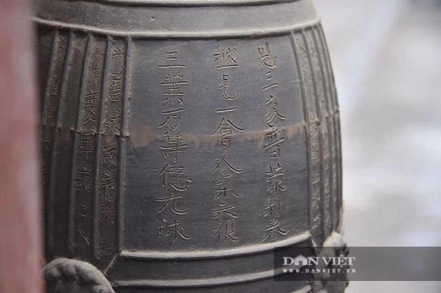 Phần trên của mặt ngoài chuông khắc chìm chữ Hán theo lối chữ chân - khắc một bài minh gồm 211 chữ, còn khá rõ, phủ kín cả 4 ô hình thang và khoảng trống giữa những đường đúc dọc. Trải qua trên 1000 năm lịch sử, những chữ khắc trong bài minh vẫn còn đẹp và rõ nét.