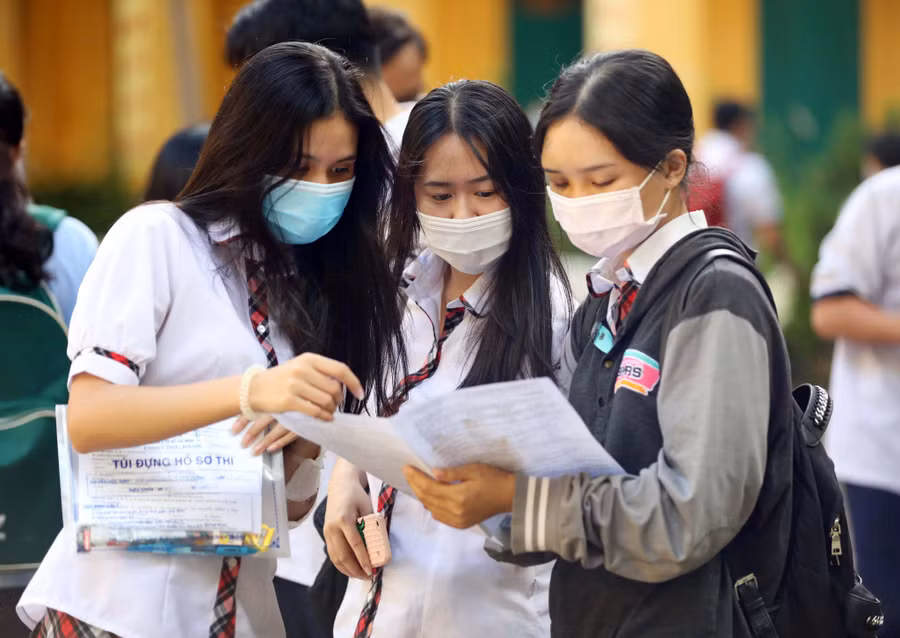  Thí sinh trao đổi với bạn bè sau khi ra khỏi phòng thi trong Kỳ thi tốt nghiệp THPT năm 2020 - Ảnh: Ngọc Dương