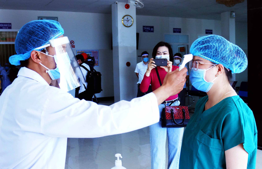 Phóng viên Như Nguyện tác nghiệp tại điểm tiêm vắc xin phòng Covid-19 ở Bệnh viện Đa khoa tỉnh. Ảnh: Hùng Hoa Lư