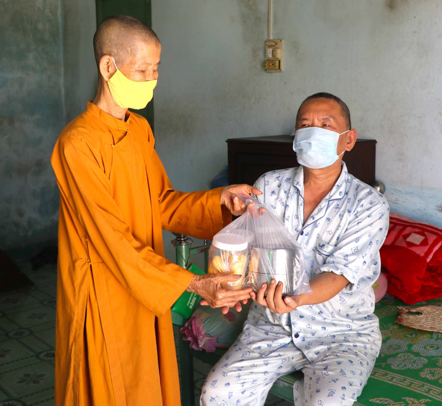 Không chỉ được hỗ trợ xây nhà, hàng ngày, ông Phạm Minh Đăng (bìa phải_ tổ 3, phường Tây Sơn, thị xã An Khê) được tịnh xá Ngọc Trung cưu mang. Ảnh Ngọc Minh