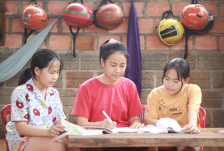 Đoàn Thị Nhị Thảo (ở giữa) hướng dẫn bài cho 2 em gái. Ảnh: Thủy Bình