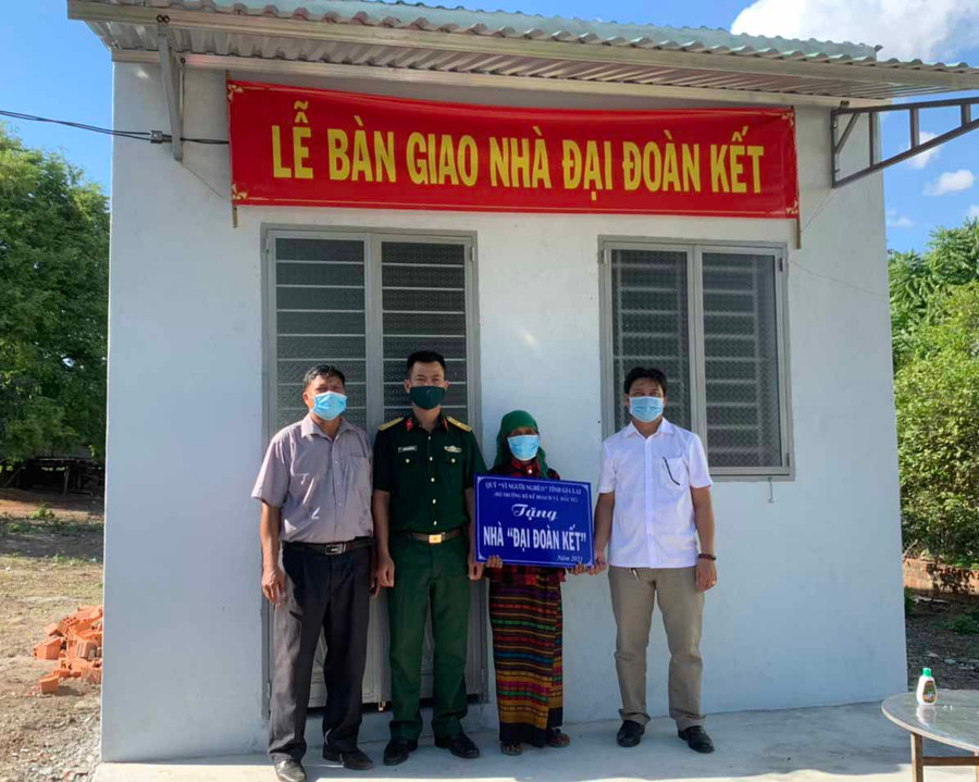 Thiếu tá Nguyễn Thanh Bình-chính trị viên phó Tiểu đoàn 2 (Trung đoàn 48) cùng lãnh đạo địa phương trao nhà Đại đoàn kết cho bà Mlô H'Prao (buôn Krãi, xã Ia Rbol).Ảnh.Vũ Chi