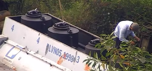 Dùng kéo cắt niêm nhựa trên nắp hầm chứa xăng.