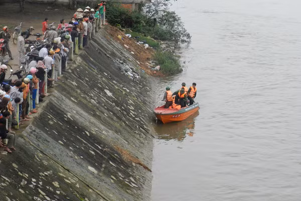Lực lượng cứu hộ và bà con trong thôn xóm tìm kiếm được xác cháu Minh. Ảnh: Trường An