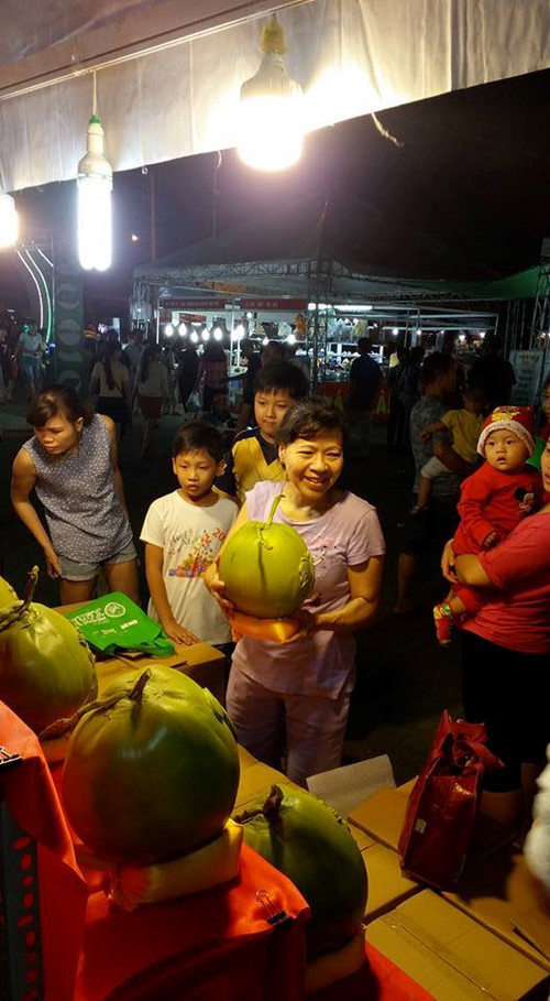 Tại một hội chợ, người dân thích thú với dừa in hình nổi