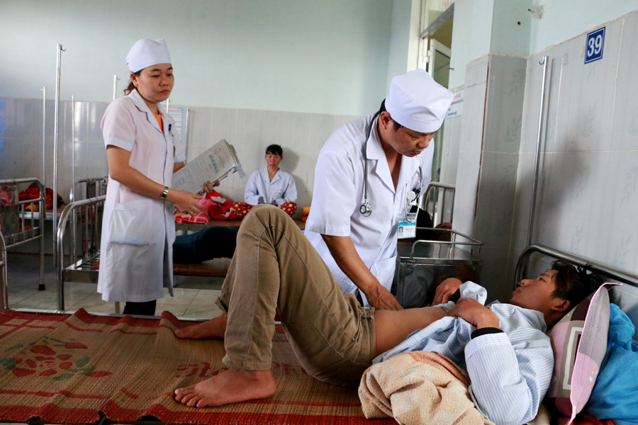 Bác sĩ Phạm Chí Quang thăm khám bệnh cho các bệnh nhận bị bệnh sốt xuất huyết tại trung tâm. Ảnh: Q.T
