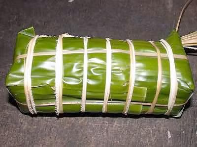 Sau đó bạn gấp lá chuối lại, dùng lạt buộc cho thật đều. Sau đó bạn gấp lá chuối lại, dùng lạt buộc cho thật đều.