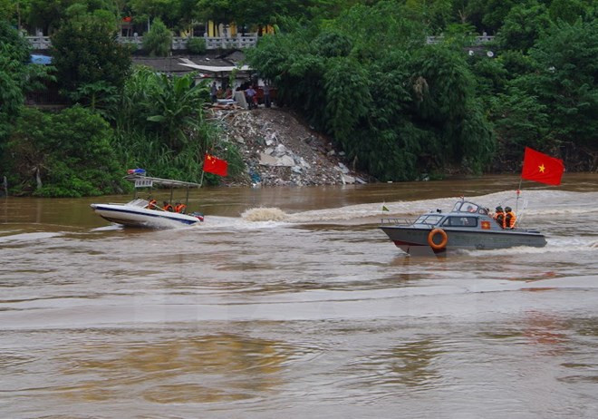 Lực lượng biên phòng hai bên tuần tra chung trên sông hồng. (Ảnh: Hồng Ninh/TTXVN)
