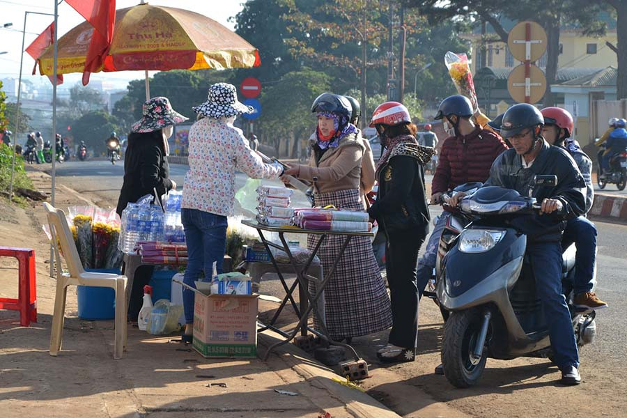 Người dân mua nhang, hoa trước khi vào nghĩa trang. Ảnh: Ngọc Thu