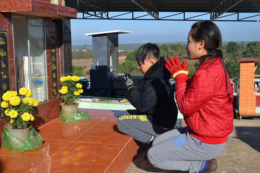 Trẻ em trong bộ quần áo mới cũng được cha mẹ chỉ dạy tri ân tổ tiên. Ảnh: Ngọc Thu