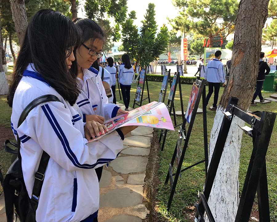 Các em học sinh chăm chú đọc báo xuân được trưng bày tại Hội Báo Xuân. Ảnh: P.L