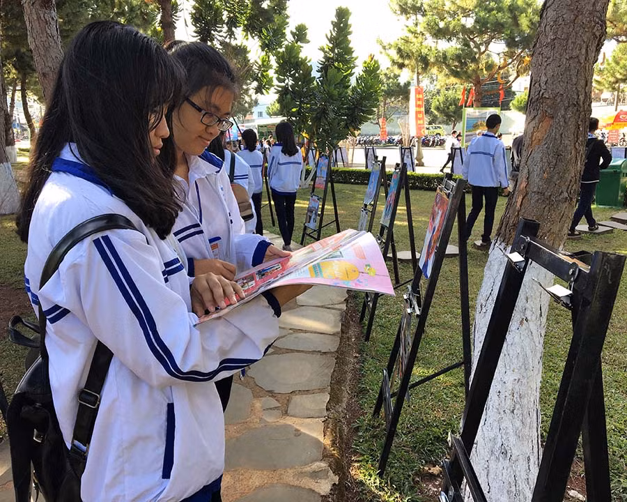 Các em học sinh chăm chú đọc báo xuân được trưng bày tại Hội Báo Xuân. Ảnh: P.L