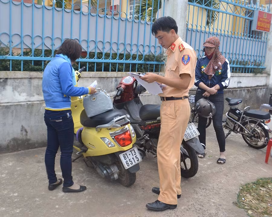 Lực lượng Cảnh sát Giao thông kiểm tra xe đến sang tên đổi chủ. Ảnh: D.Q