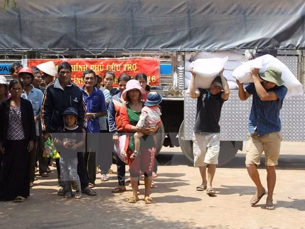 Cấp gạo cho các hộ khó khăn bị ảnh hưởng do hạn hán tại xã Đắk Lắk. (Ảnh: Dương Giang/TTXVN)