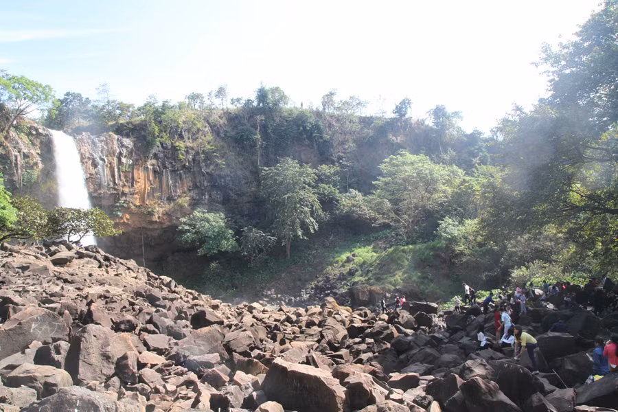 Người dân chọn bóng mát của tán cây bên cạnh thác làm chỗ dừng chân. Ảnh: Văn Ngọc