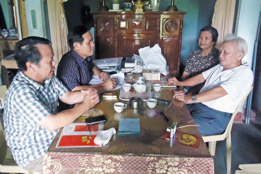 Ông Nguyễn Thái Thưởng (bìa phải) trò chuyện với tác giả (áo ca rô). Ảnh: Quốc Ninh