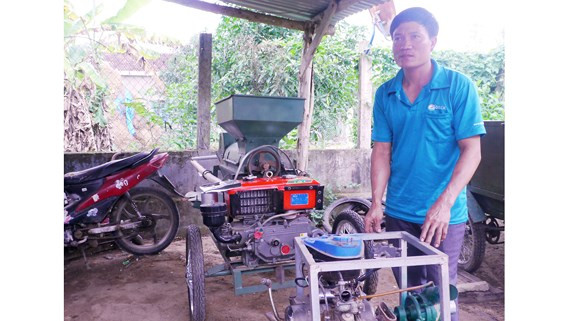 “Kỹ sư làng” Lê Văn Thành bên máy tách hạt bắp do anh sáng chế “Kỹ sư làng” Lê Văn Thành bên máy tách hạt bắp do anh sáng chế
