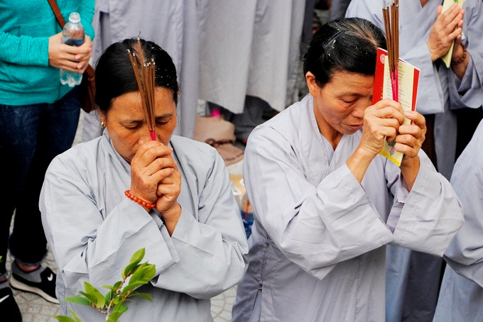  Các phật tử trong trang phục áo dài chú tâm cầu nguyện.