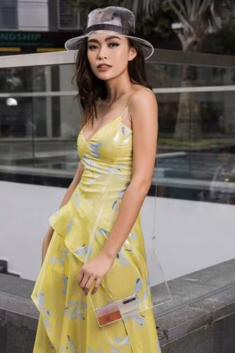  Trên nền váy 2 dây màu vàng với chi tiết bèo chéo gợi cảm, Á hậu Mâu Thủy kết hợp với nón và túi xách trong suốt.