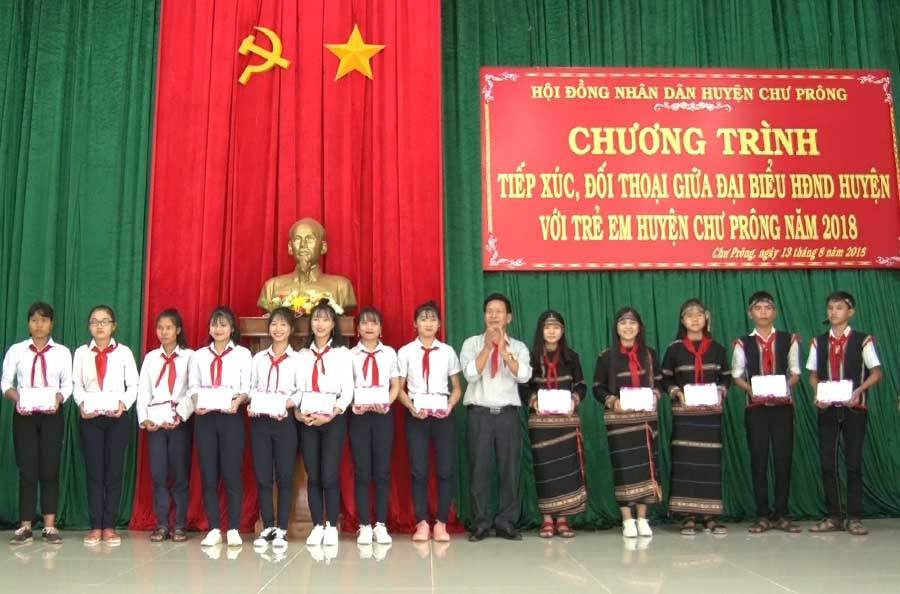 1Đồng chí Bùi Viết Hội tặng quà cho các em học sinh trong buổi đối thoại. Ảnh: Khánh Linh