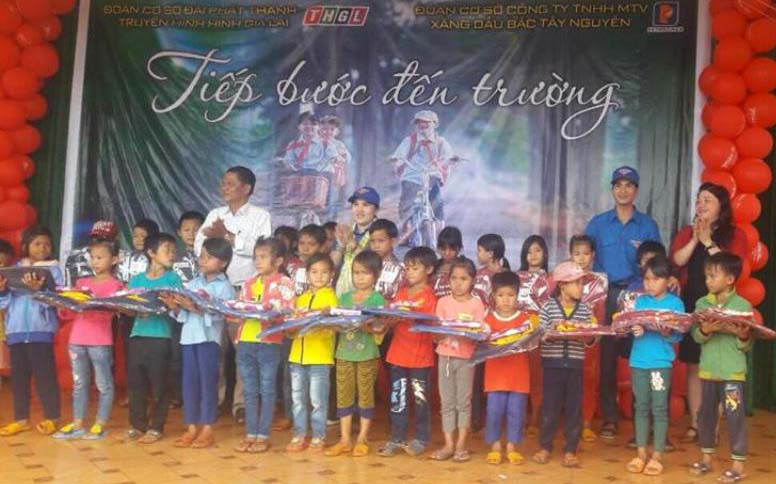Tặng cặp sách cho các em học sinh. Ảnh: Phan Lài