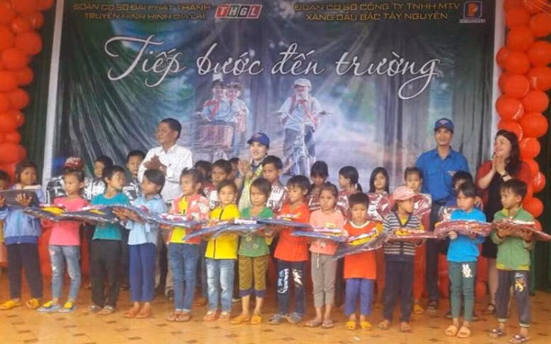 Tặng cặp sách cho các em học sinh. Ảnh: Phan Lài