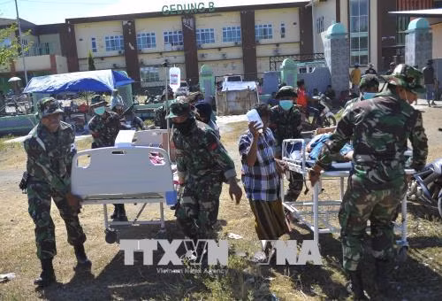 Binh sĩ Indonesia chuyển nạn nhân bị thương sau trận động đất tới lều cấp cứu tạm thời ở Lombok ngày 7/8. Ảnh: THX/TTXVN