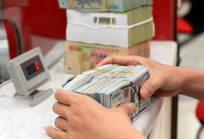  Giao dịch tiền tệ tại chi nhánh Techcombank Hà Nội. Ảnh: Hải Linh