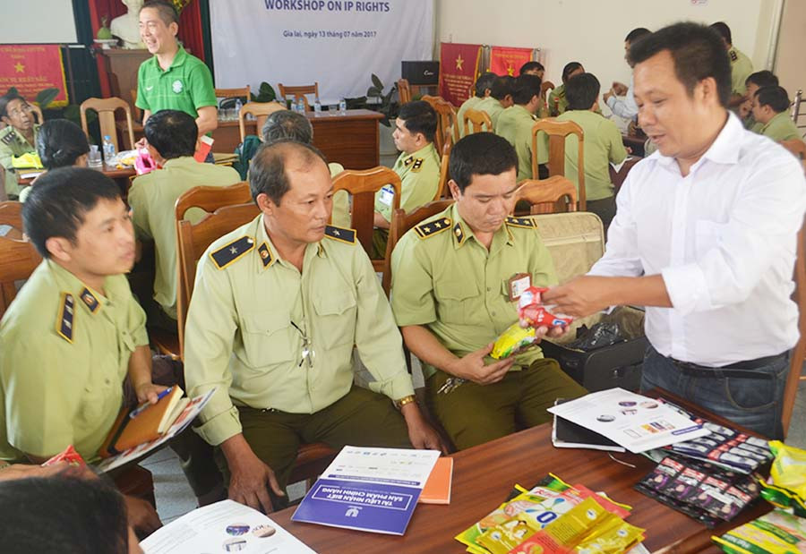 Cán bộ Quản lý Thị trường tập huấn kỹ năng phân biệt hàng thật và hàng giả mạo thương hiệu. Ảnh: D.Q