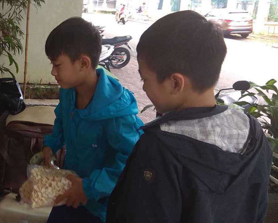  Hai anh em Trần Văn Thành mời khách mua bắp rang bơ. Ảnh: A.N