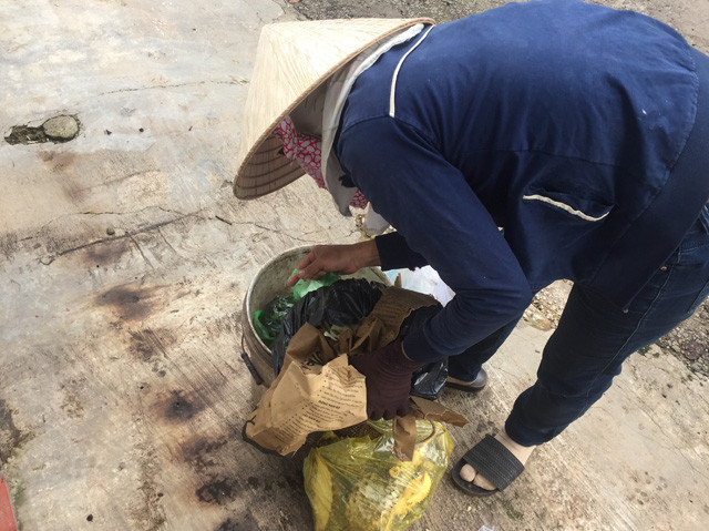 Chị Hạnh đang bới thùng rác để tìm hạt sầu riêng.