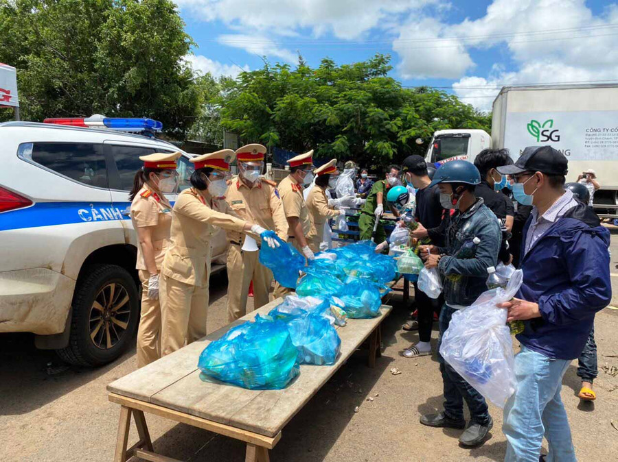 Lực lượng CSGT tỉnh hỗ trợ lương thực cho người dân về từ các tỉnh phía Nam tại chốt kiểm soát phòng-chống dịch Covid-19 khu vực cầu 110 (huyện Chư Pưh). Ảnh: Hạ Vy