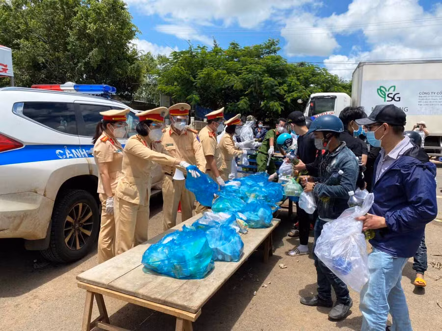 Lực lượng CSGT tỉnh hỗ trợ lương thực cho người dân về từ các tỉnh phía Nam tại chốt kiểm soát phòng-chống dịch Covid-19 khu vực cầu 110 (huyện Chư Pưh). Ảnh: Hạ Vy