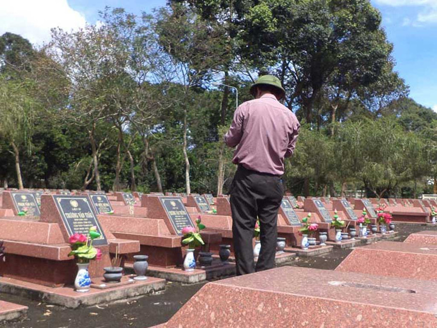 Ông Nguyễn Sỹ Hồ chụp ảnh tại một nghĩa trang liệt sĩ