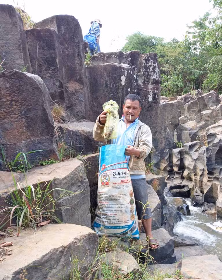 Ông Rơ Châm Vân-Chủ tịch UBND thị trấn Ia Ly (huyện Chư Păh) thu dọn rác thải sinh hoạt do du khách vứt tại suối Đá Đĩa (làng Vân). Ảnh: R’Ô HOK
