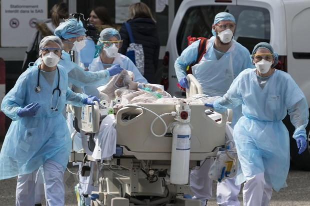 Nhân viên y tế chuyển bệnh nhân COVID-19 tại bệnh viện. (Ảnh: AFP/TTXVN) Nhân viên y tế chuyển bệnh nhân COVID-19 tại bệnh viện. (Ảnh: AFP/TTXVN)