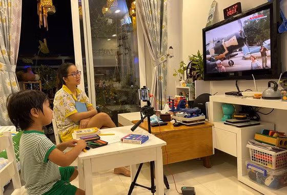 Chị Ngọc Quỳnh (quận 7) và con trai đang “tham quan” bảo tàng qua mạng. Ảnh: Hoàng Hùng