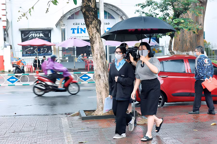 Để động viên tinh thần và đảm bảo an toàn cho con trước kỳ thi quan trọng, nhiều phụ huynh đã “đội mưa” đưa thí sinh đến điểm thi. Ảnh: Hồng Thi